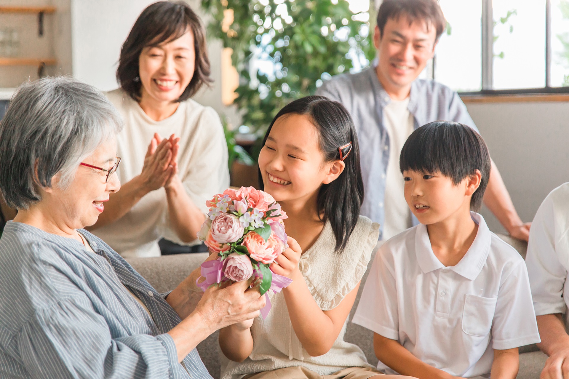 孫から花束をもらう高齢者女性